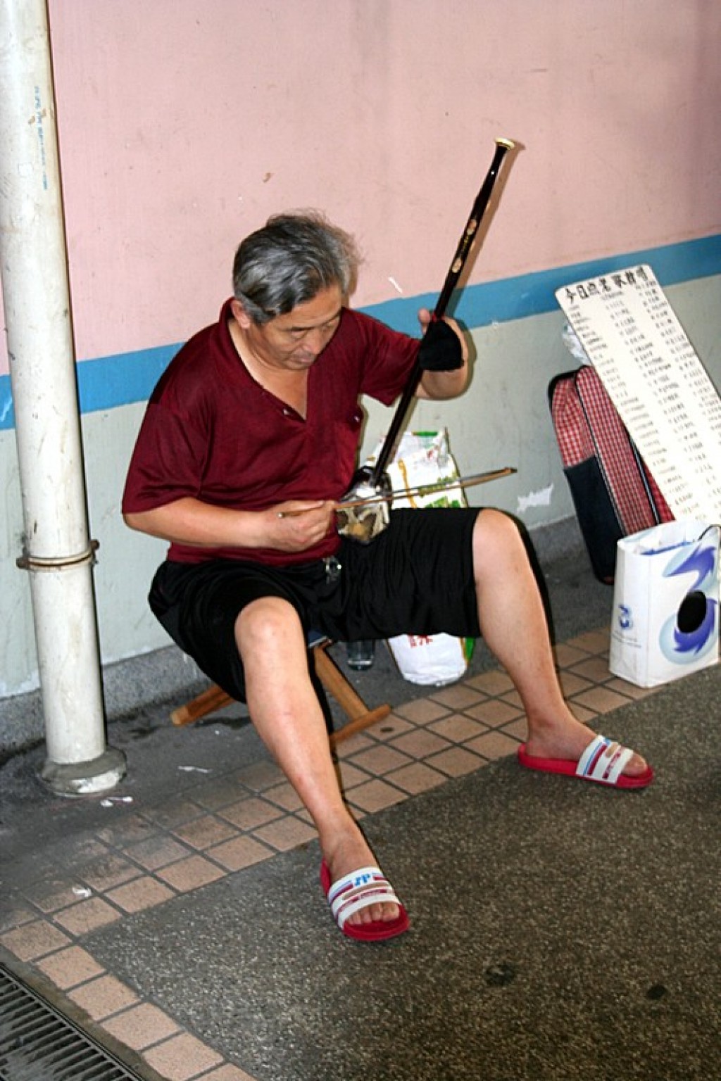 Man playing a traditional instrument in the subway on the way to the tram.